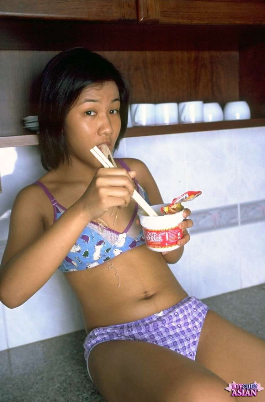 Cute Asian girl shows the pink of her pussy after eating noodles page 1