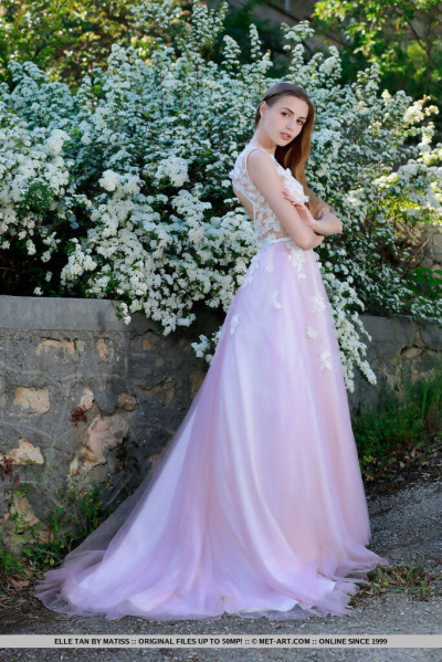 جميلة فتاة Elle تان زلات قبالة الزفاف اللباس إلى تشكل عارية في حديقة