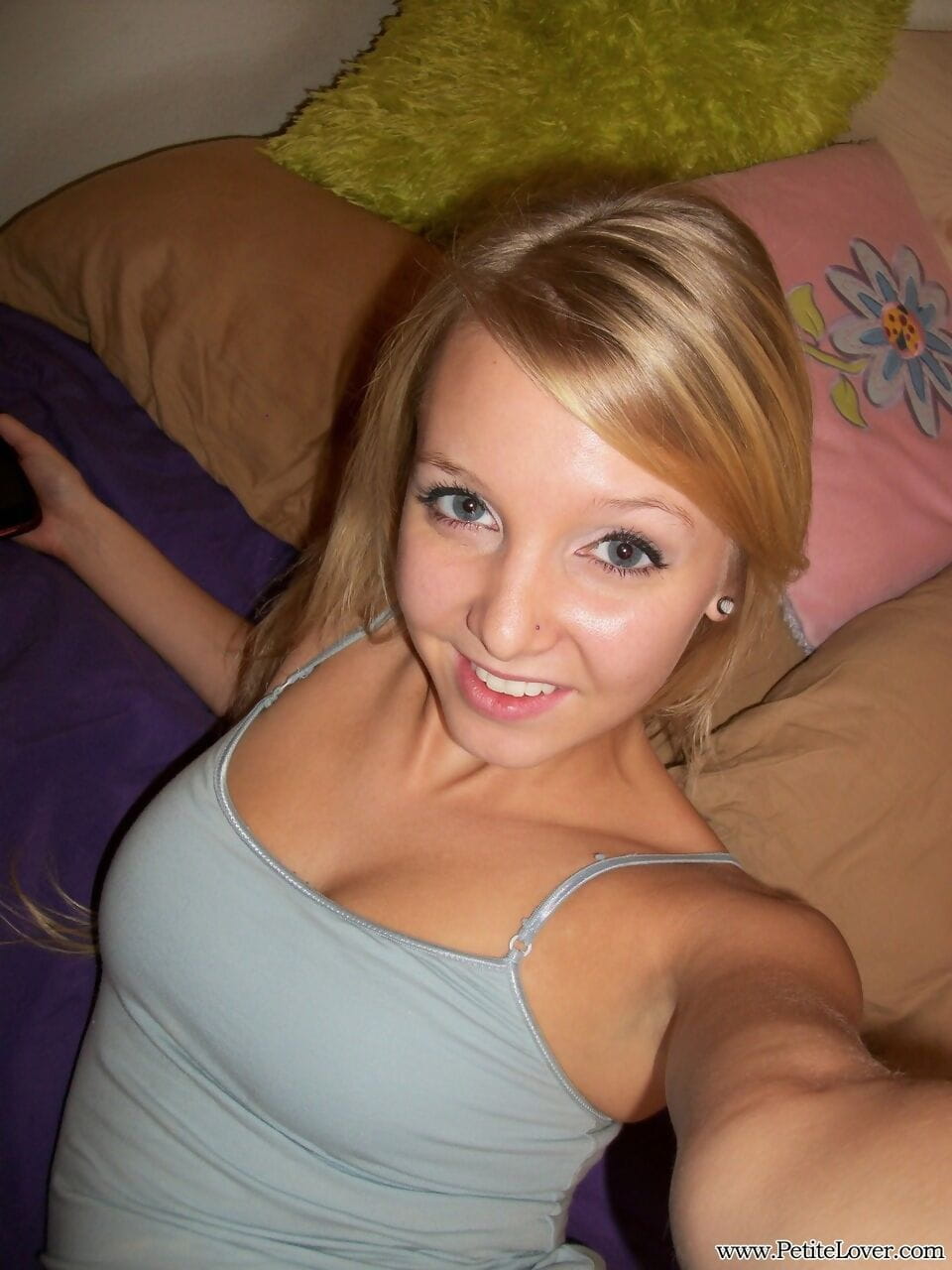 Cute teen girl with blonde hair displays her hairless pussy on her bed page 1